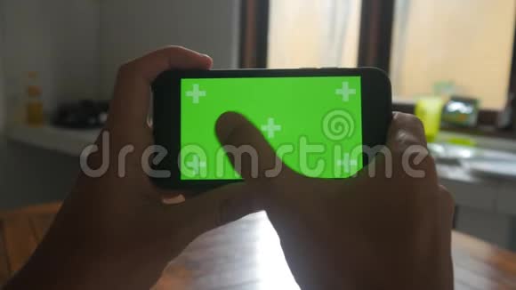 厨房中男性手触摸智能手机的特写绿色屏幕Chroma键视频的预览图