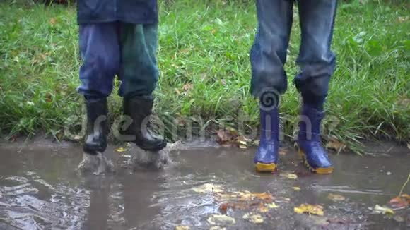 两个男孩在泥泞的水坑里跳慢动作250英尺视频的预览图