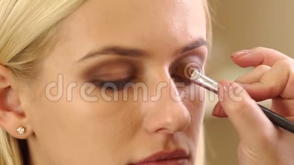年轻女孩在美容院为女人化妆视频的预览图