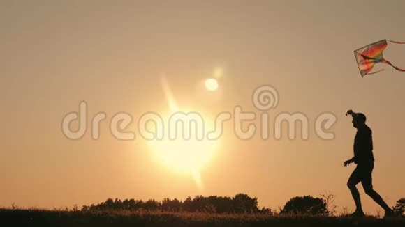 一个幸福的家庭一家人在夏天的夕阳下发射风筝飞向天空视频的预览图