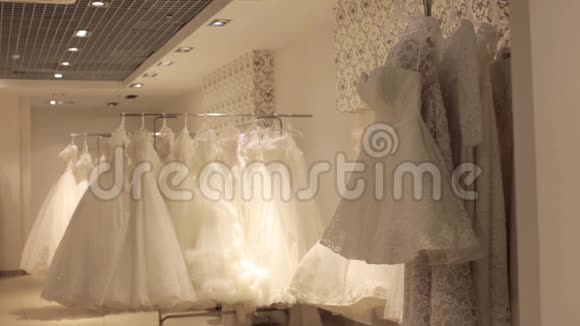 年轻漂亮的女人在婚礼店里挑选白色礼服Wed概念视频的预览图