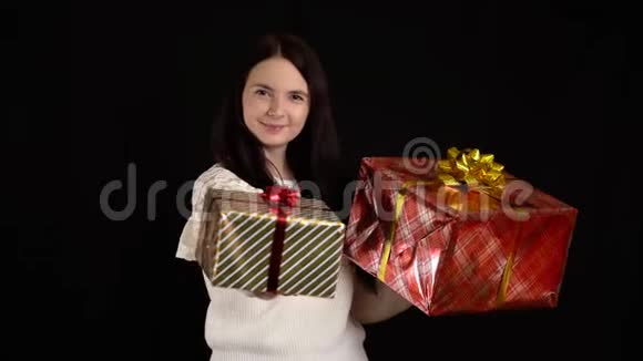 带黑背景礼盒的年轻女人圣诞快乐带白色丝带的礼品盒视频的预览图