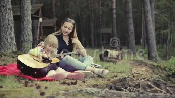 年轻的母亲和小女儿在森林里休息视频的预览图
