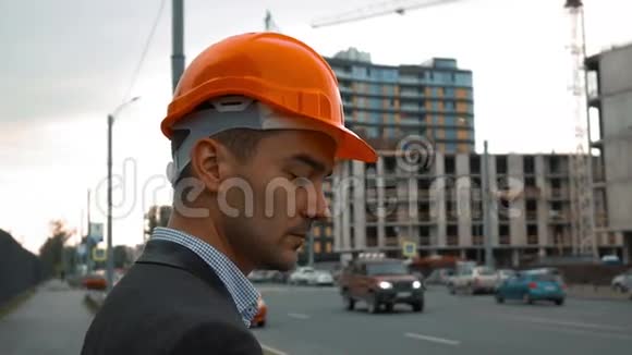 戴橙色头盔的建筑工人正在打电话视频的预览图