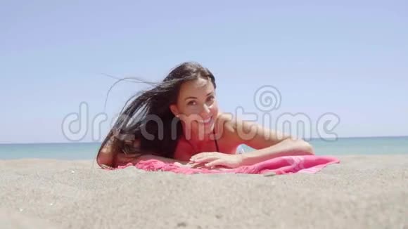 令人兴奋的年轻女子躺在沙滩上视频的预览图