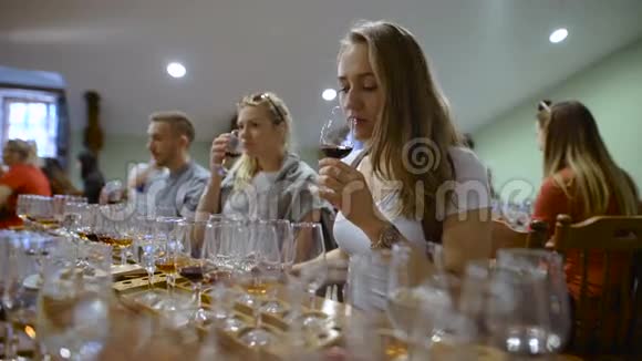 一群年轻人在品酒女孩拿着一杯酒尝着饮料的味道和气味视频的预览图