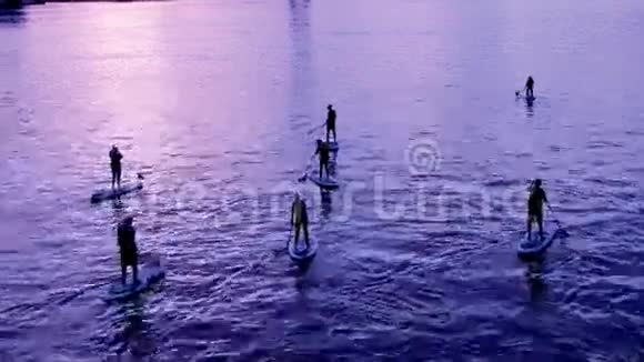 一群人在美丽的夕阳下站起桨板冲浪视频的预览图