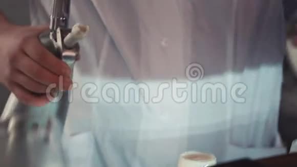 酒保在酒吧柜台用玻璃倒入起重机上的泡沫饮料酒精鸡尾酒视频的预览图