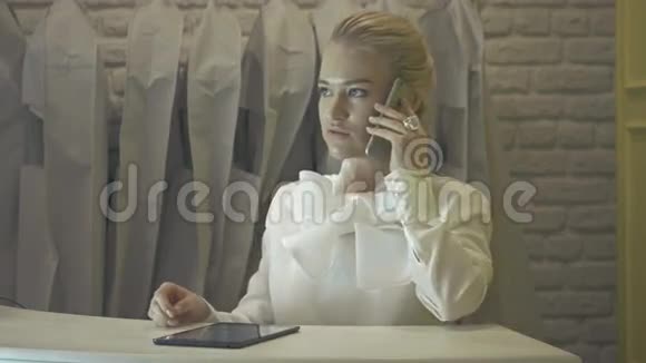 带智能手机的婚纱店女销售助理视频的预览图