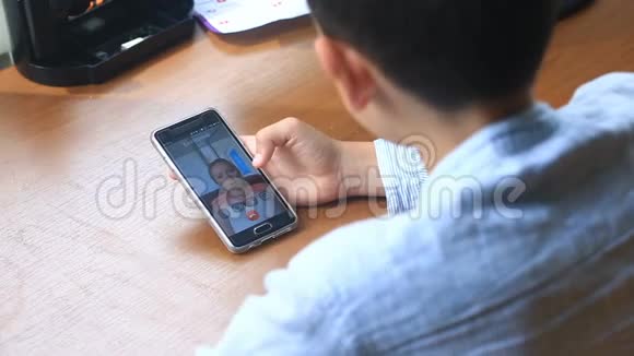 少年男孩在智能手机上和女人视频聊天视频的预览图