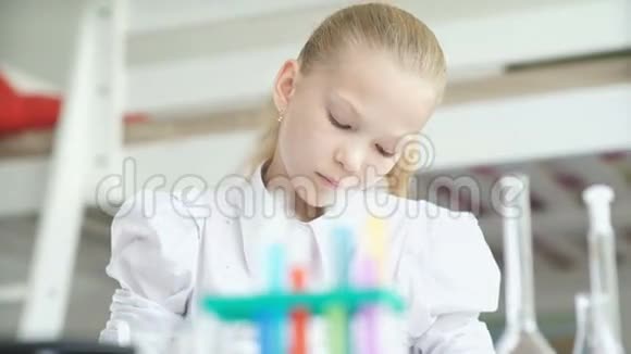 女孩做化学实验用试管站在桌子上视频的预览图