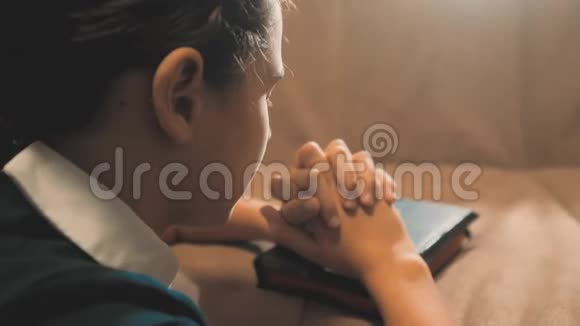小女孩在夜里祈祷小女孩用手祈祷小女孩圣经在圣经中祈祷视频的预览图