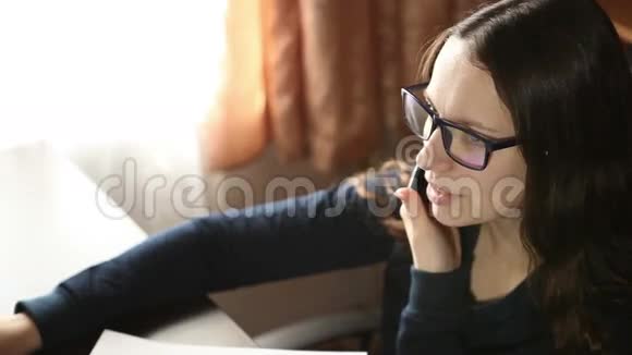 戴眼镜的女孩一边打电话视频的预览图