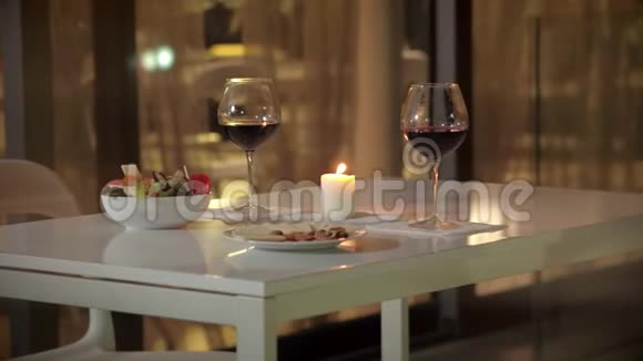 为两人提供浪漫晚餐的红酒杯为夫妇提供晚餐视频的预览图