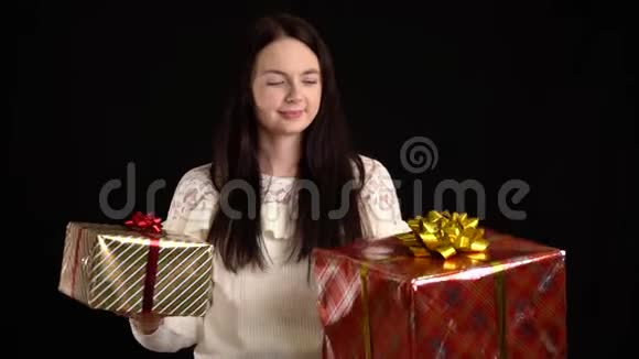 带黑背景礼盒的年轻女人圣诞快乐带白色丝带的礼品盒视频的预览图