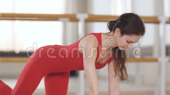 穿红色运动服的女孩做体式瑜伽练习视频的预览图