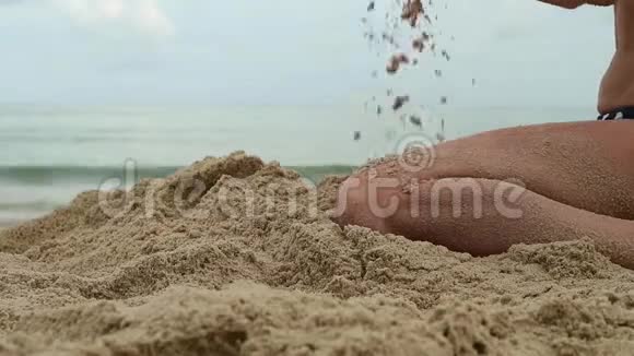 女人的手在异国海滩和模糊的海洋背景下玩沙子暑假概念视频的预览图
