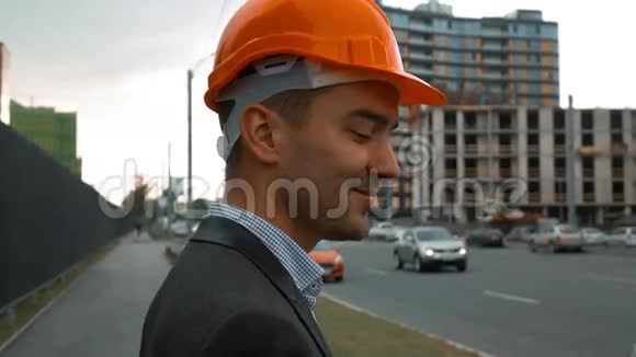 戴橙色头盔的建筑工人正在打电话视频的预览图