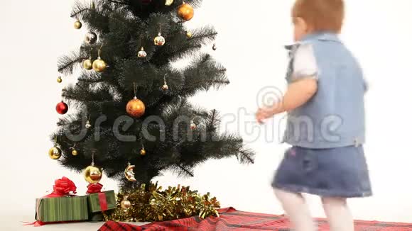 小女孩在圣诞树下接受礼物视频的预览图
