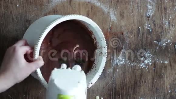 顶部观看搅拌巧克力饼干面团与电动搅拌器在白色塑料碗加速视频视频的预览图