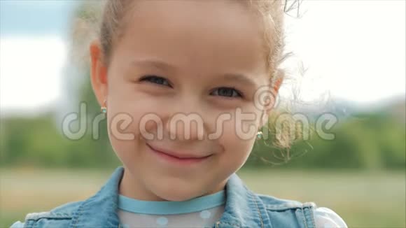特写肖像可爱快乐的白种人小女孩微笑着看着镜头享受着温暖的暑假晴天视频的预览图