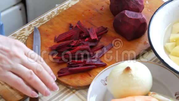 女性的手在家中的厨房板上剪甜菜视频的预览图