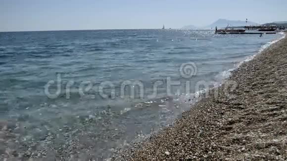 海浪在卵石海滩上特写太阳在海浪中反射地中海视频的预览图