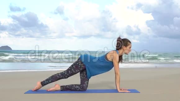 年轻女子在海边训练晨练体操做腿部运动健康活跃的生活方式理念视频的预览图