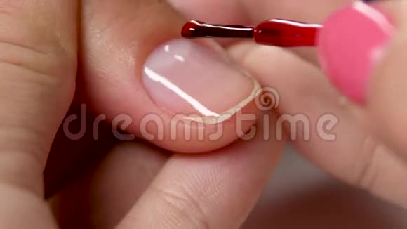 用红色清漆盖住指甲修指甲的最后阶段关门视频的预览图