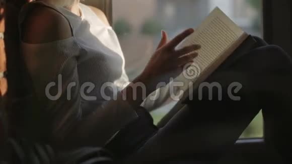 年轻的女人在家坐在窗户附近看书放松视频的预览图