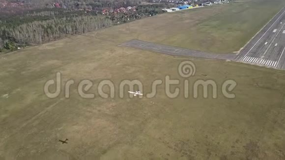 在机场跑道附近飞行的小型螺旋桨飞机视频的预览图