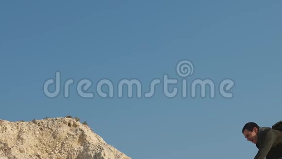 登山者在白色的岩石上一个接一个地爬游客们互相伸手爬到山顶团队合作视频的预览图