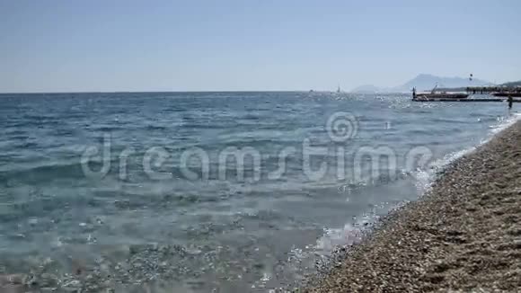 海浪在卵石海滩上特写太阳在海浪中反射地中海视频的预览图