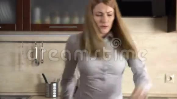 快乐美丽的年轻女商人早上在厨房里玩得很开心疯狂地跳舞视频的预览图