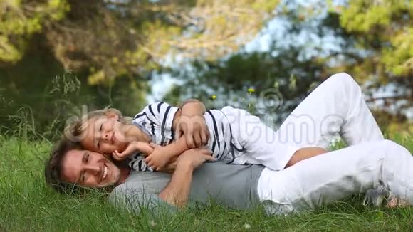 父子俩躺在草地上看着摄像机视频的预览图