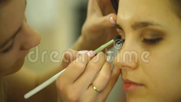 化妆的过程化妆师在模特脸上用刷子工作视频的预览图