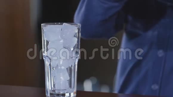 蓝色饮料倒入玻璃杯中加冰和鸡尾酒的杯子酒吧里的异国情调饮料慢动作视频的预览图