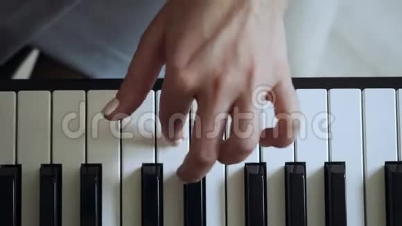 从小女孩在电钢琴上弹奏的老师的俯视图视频的预览图