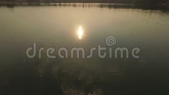 空中拍摄一个湖有一条阳光明媚的小路一个人沿着它游泳视频的预览图