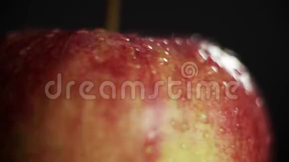 苹果被水滴覆盖近距离旋转黑色背景上的水果视频的预览图