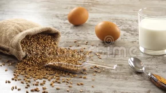 在一张乡村的木桌上放着小麦牛奶鸡蛋和新鲜面包乡村早餐视频的预览图