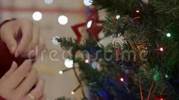 把女人的手挂在圣诞树上的古董玩具上视频的预览图