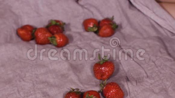 孩子搓手女孩带着一大盘草莓看着相机孩子手里拿着浆果高清高清视频的预览图