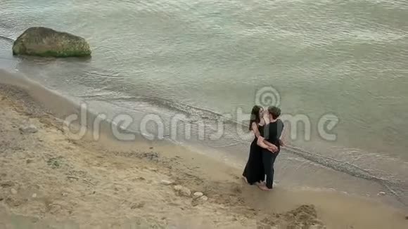 穿着黑色衣服拥抱在海边的情侣视频的预览图