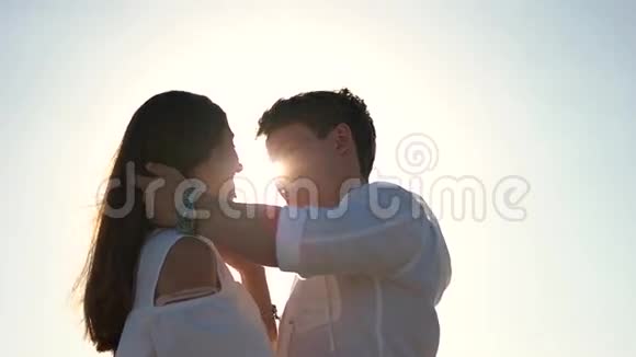 在蓝天背景下接吻的情侣视频的预览图
