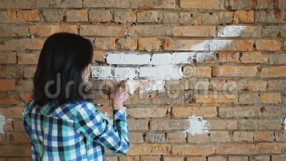 女人在房子里画一块白色的红砖视频的预览图