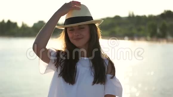 戴帽子的女孩在大海的背景上微笑视频的预览图
