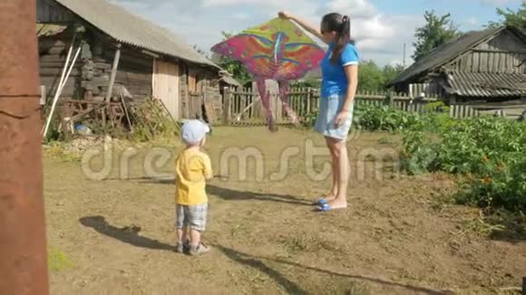 夏天一位带着婴儿的年轻母亲在绿色的田野里放风筝妈妈做得不好儿子很高兴视频的预览图