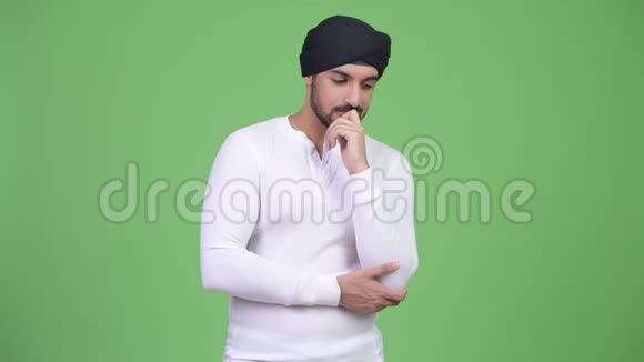 一个长着大胡子的印度年轻人低头思考视频的预览图