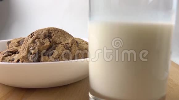 手拿巧克力饼干和一杯牛奶作为早餐4K型特写镜头视频的预览图